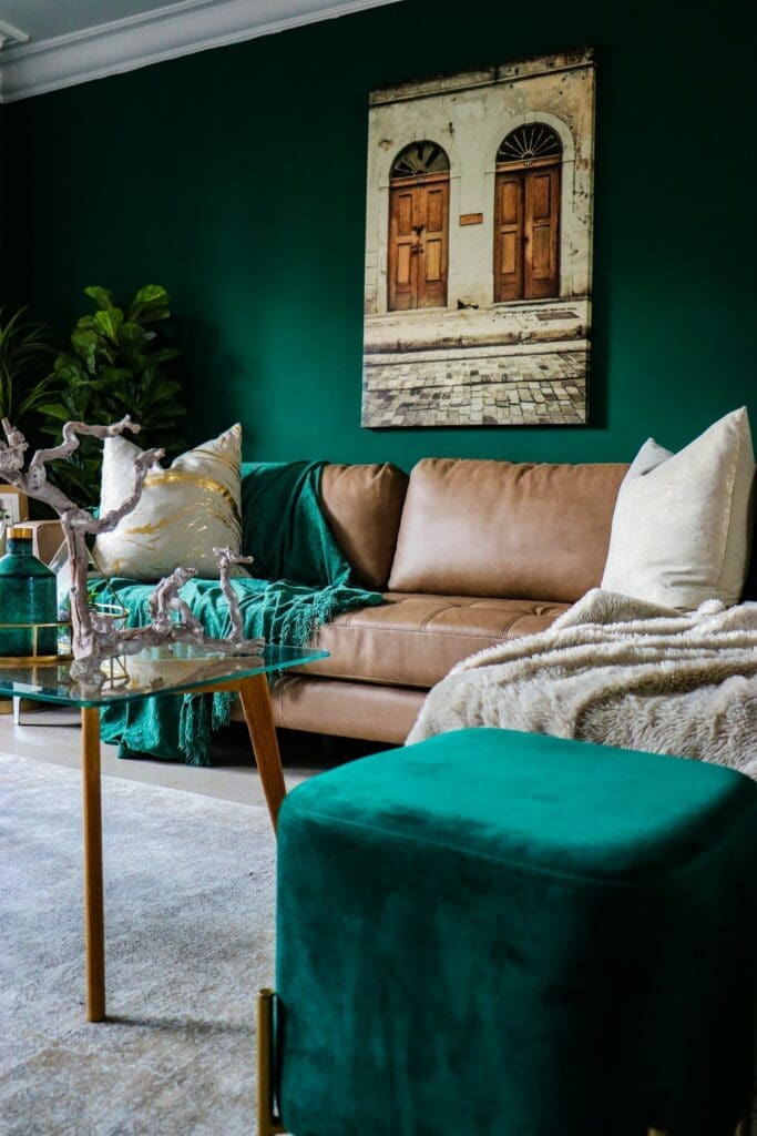 
A beautifully styled living room with a harmonious green, brown, and beige aesthetic, featuring a comfortable brown sofa against a green accent wall. The warm, earthy tones create a welcoming and elegant atmosphere, perfect for those ready to move up with lease to own homes.