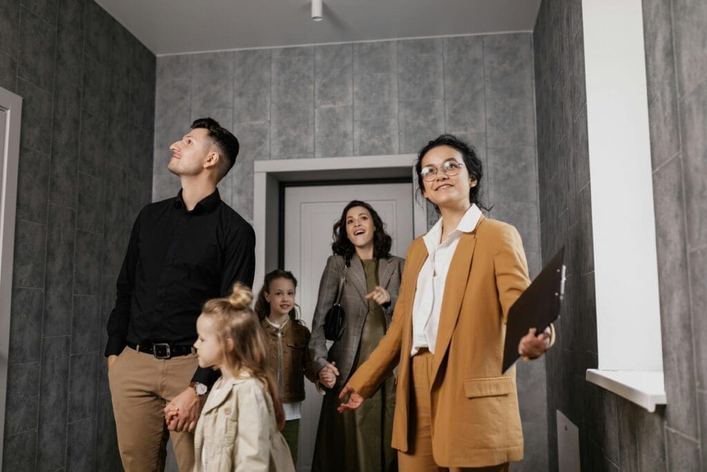 Family touring a modern home with a real estate agent, representing a Lease-to-Own Raleigh opportunity while keeping their current house rental-ready.