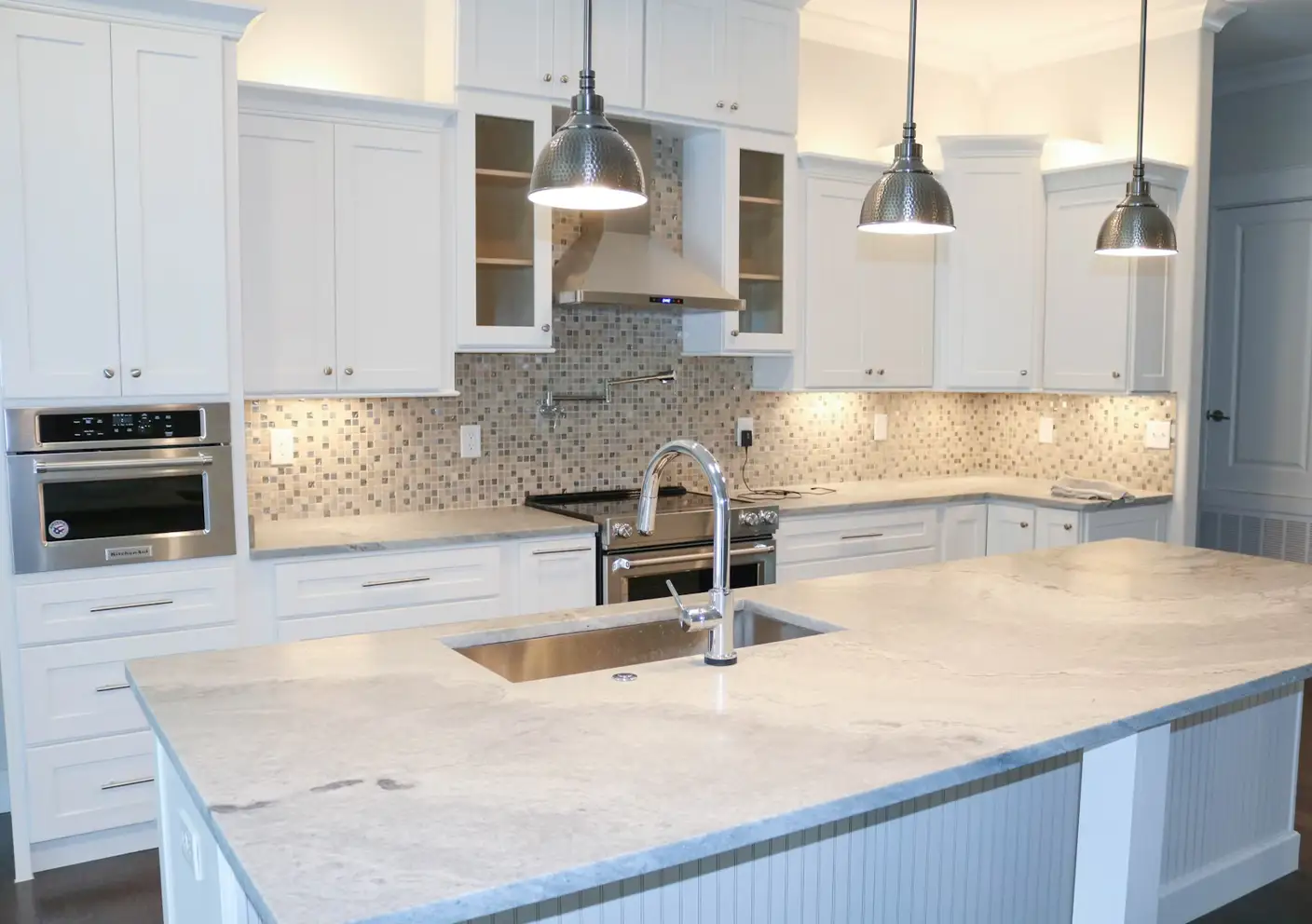 Bright, modern kitchen in a lease to own Greensboro home with sleek white furniture and cabinetry, natural light, and clean design elements.